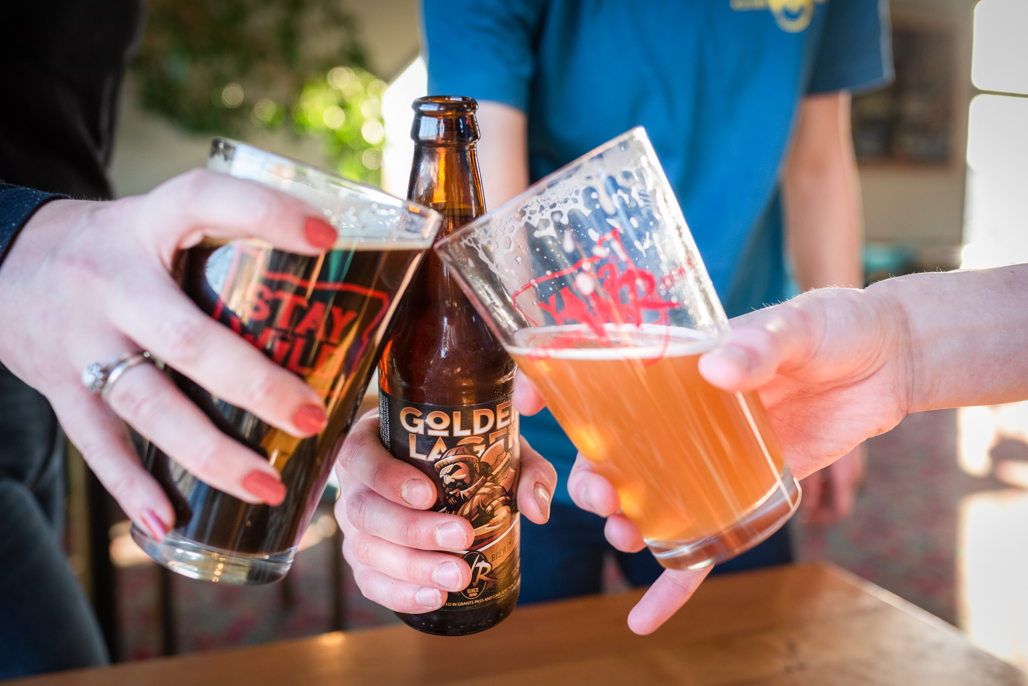 a hand holding a glass of beer on a table